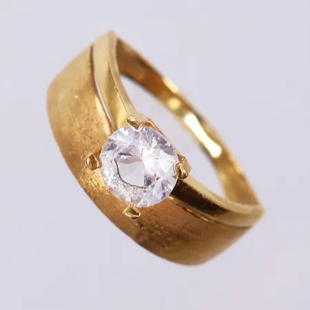 Ring med vit sten, stl 18½, ca bredd 2-9,5mm, skev, sneda klor, ostämplad. 18K  Vikt: 4,5 g