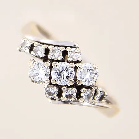Ring med diamanter, totalt 0,66ctv enligt gravyr, två stycken av de mindre diamanter är troligen syntetiska, stl 17½, bredd 2-10mm, vitguld, spår av storleksändring, i behov av omrodiering, 18K  Vikt: 3,9 g