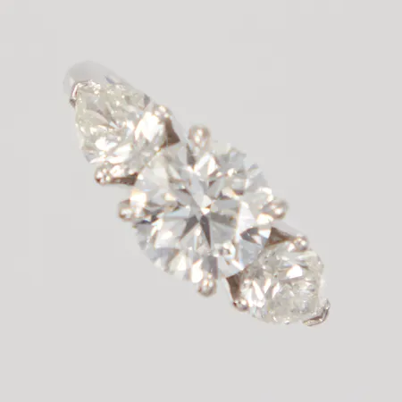Ring med briljantslipad diamant 1,68ct, kvalitet H/SI1 enligt HRD certifikat, lasergraverad rondist nr: 180000135007, 2xca 0,50ct droppformade diamanter ca TCr-Cr/VS-SI, stl: 15¼, bredd 2,9-7,5mm, 18K Vikt: 4,6 g