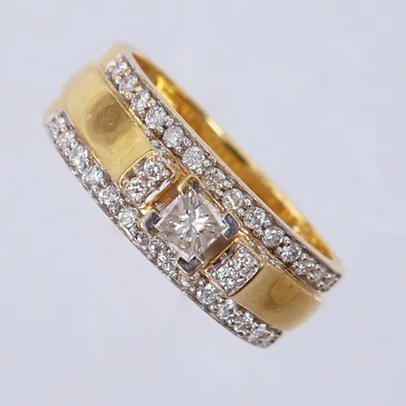 Ring med diamanter ca 1x0,20ct prinsesslipad, 40x0,01ct 8/8-slipade, stl 17½, bredd 6,2-7,3mm, GHA. 18K  Vikt: 6,7 g