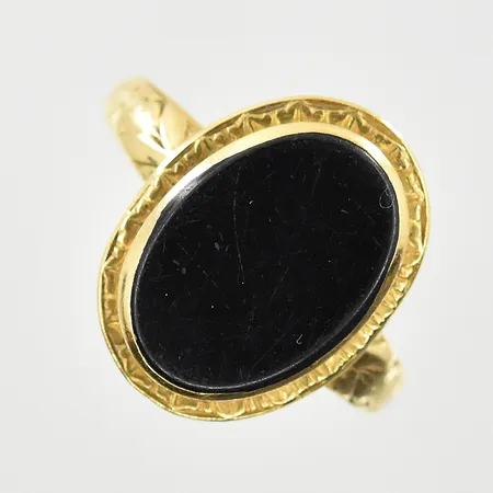 Ring med onyxplatta, stl 18, bredd 2-17 mm, något sliten sten, 18K. Vikt: 3,1 g