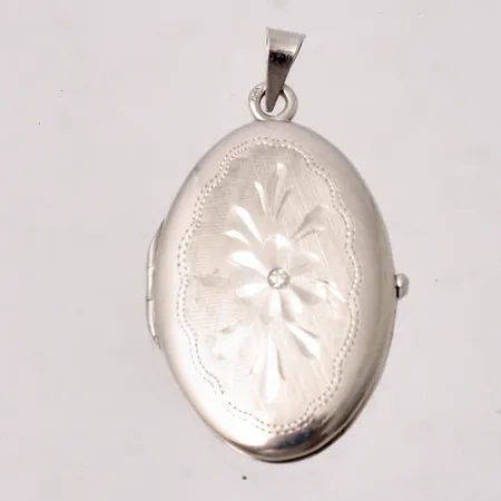 Medaljong/fotogömma i 18K vitguld, mått 21x39,2mm, 1st vit sten, mått Ø1,4mm, importstämpel, vikt 6,3g.