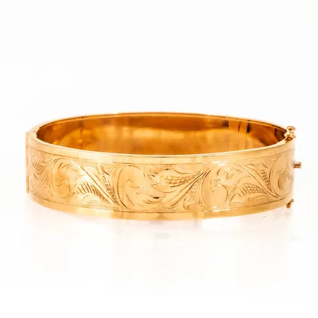 Armring i 18K guld med mönstergravyr. Innermått 18 cm, 59 x 54 mm. Det är 15 mm brett och väger 24,2g. Stämplad 18K & svensk importstämpel. Repor. 
