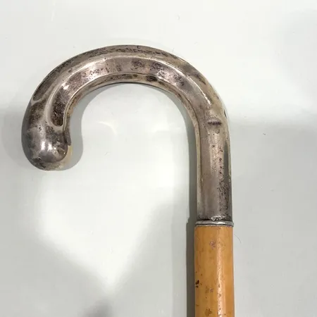 Käpp i trä med silverhandtag, längd ca 89cm, bredd ca 20-22mm, trä med repor samt slitage, handtag med bucklor samt gravyr Skickas med postpaket.
