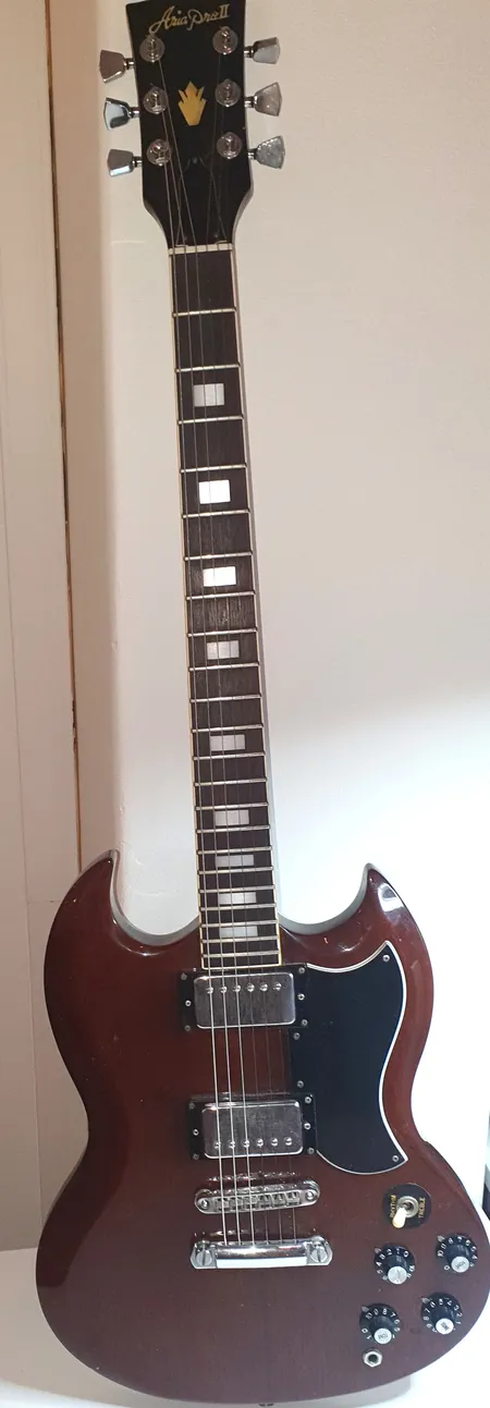 Elgitarr Aria pro 11 SG 1975-80s Heritage cherry Japan ,några nagg , något böjd switch,  mycket slitet hårt fodral, inte orginal,  Vikt: 0 g Skickas med Bussgods eller PostNord