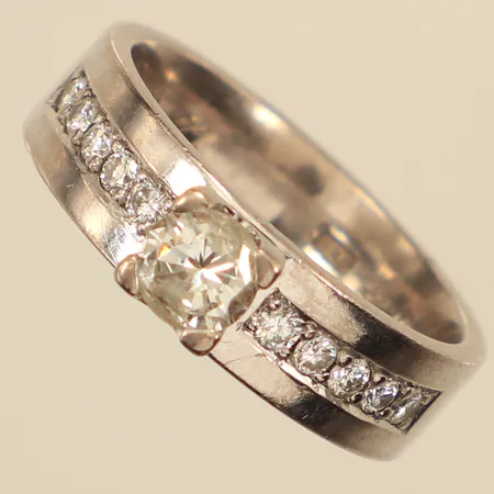 Ring, diamanter 1xca0,65ct,10xca0,02-0,03ct, stl 18¾, bredd 6,1mm, vitguld, gravyr, 18K Vikt: 10,9 g