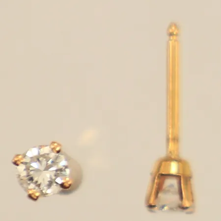 Ett par örhängen med diamanter ca 2 x 0,16ct, varav en indikera syntetisk, ca 3,5mm, saknar snurrebussar, 14K Vikt: 0,5 g