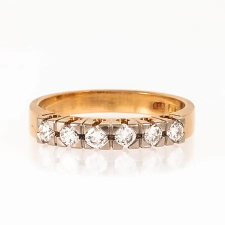 Ring i 18K guld med 6 x 0,08ct briljantslipade diamanter. Den är i storlek 19, är 3,1 - 3,3 mm bred och väger 5,0g. Stenstorlek 0,48ct ingraverad. Stämplad C10 (1977), HE (Heribert Engelbert AB, Stockholm), STIGBERT, 18K & kattfot. 