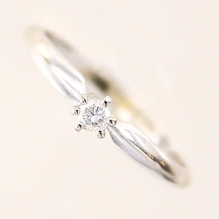 Ring med diamant ca 0,07ct, stl 15¼, bredd 1,6-3,6mm, skev, sneda klor, vitguld, 14K Vikt: 1,4 g