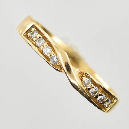 Ring med vita stenar, stl 16, bredd 3 mm, något skev skena, svag gravyr, 18K. Vikt: 1,9 g