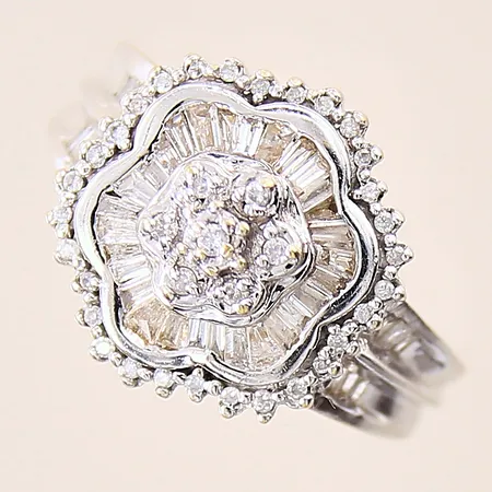 Ring med diamanter, 30 x ca 0,005ct + 7 x ca 0,01ct, ca 41 x 0,01-0,02ct trapettsslipning, stl 17½, bredd 2-17mm, vitguld, något bucklig skena, 18K  Vikt: 7,9 g