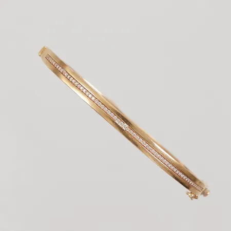 Armring med vita stenar, innermått ca 63x48mm, Ø ca 17,5cm, bredd 3-4,6mm, ostämplad 18K Vikt: 9,7 g