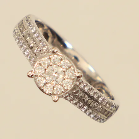 Ring, diamanter 1xca0,05ct 23xca0,01ct 40xca0,005ct, stl 15¾, bredd 3,4-5,8mm, vitguld. GHA, 18K Vikt: 3,2 g