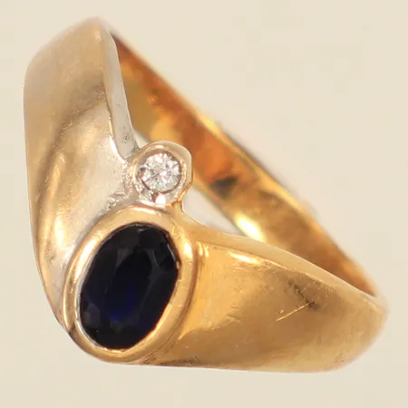 Ring med troligen syntetiska blå safir samt vit sten, 17½, bredd ca 3-10mm, tvåtonad, repig, 18K Vikt: 4,9 g