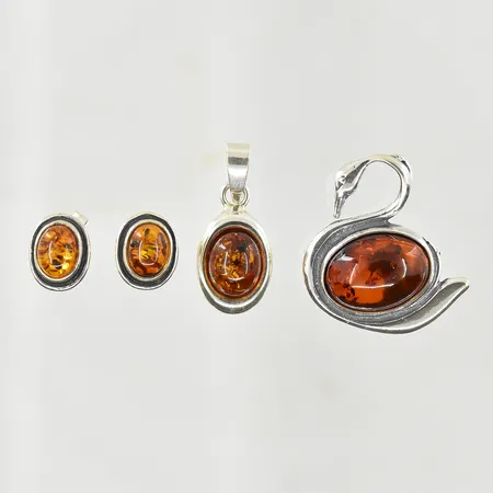 Ett hänge med bärnsten, längd 25 mm, en brosch med bärnsten, längd 27 mm, ett par örhängen med bärnsten, stl 11x9 mm, 925/1000 silver. Vikt: 9,8 g