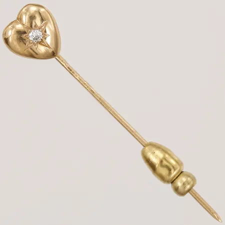 Hattnål i form av ett hjärta med diamant 1 x ca 0,02ct, längd: 43 mm, bredd: 1 - 8 mm, monogramgravyr på baksida, 18K guld. Vikt: 1,3 g