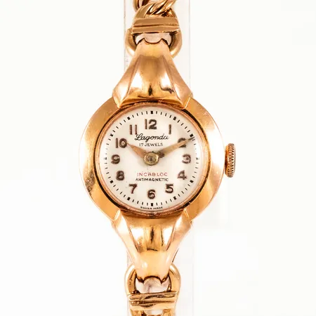 Smyckeur Lagonda 17 Jewels, Incabloc Antimagnetic i 18K guld med band bismarck i 18K. Boett Ø 20 mm, manuellt urverk, plastglas. Total längd 18,5 cm, bredd 6,5 mm, kistlås. Stämplad K9 (1960), RSV (Sture Vibergs Guldvaror, Avesta), 18K & kattfot. Bruttovikt: 21,1g. 