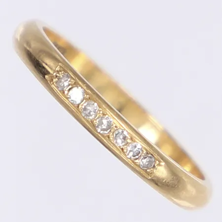 Ring med diamanter 7x ca 0,01ct, stl 17¼, bredd 2,5mm, svaga rester av gravyr i skenan, 18K Vikt: 2,7 g