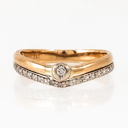 Ring i 18K röd- och vitguld med 19 x ca 0,008ct, 1 x ca 0,03ct briljantslipade diamanter. Den är i storlek 18¼, är 2,7 - 5,3 mm bred och väger 3,1g. Stenstorlek 0,20ct ingraverad. Stämplad GFAB, 750. 