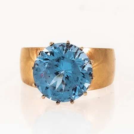 Ring i 18K guld med stor ljusblå sten Ø 12 mm. Den är i storlek 17¾, är 4,3 - 13 mm bred och väger 5,6g. 