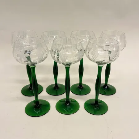 7 vitvinglas, 1900-tal, höjd 20cm, graverad dekor, klarglas med grön fot Skickas med postpaket.