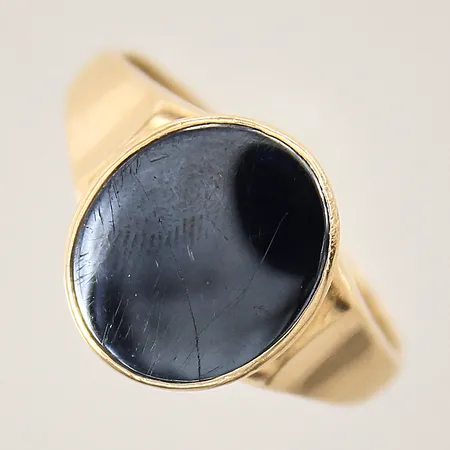 Ring med hematit, stl 20¼, bredd 3-14mm, skena med mindre hack, sten med repor, 18K  Vikt: 6,2 g