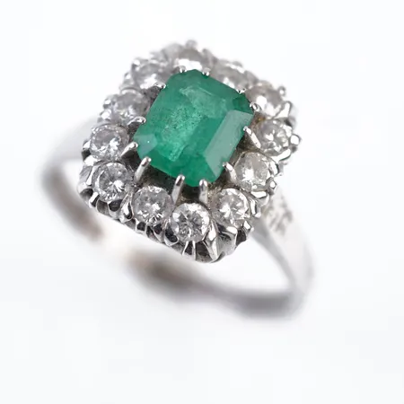 Ring m 12 briljanter 0,75ct Tw Vs och 1 smaragd 0,98ct enligt gravyr, vitguld, stl 18½(58), 13,5mm x 12,5mm, 18k, värderingsintyg samt kvitto Carl Hoff Helsingborg 2022 Vikt: 6,1 g