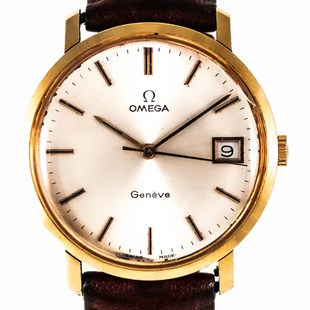Herrur Omega Genéve i 18K guld. Boett Ø 34 mm, manuell, datum, svaga repor och spricka på plexiglas, brunt läderband (ej original). Bruttovikt: 35,7g. 