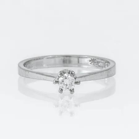 Stjärnring Pallas i 18K vitguld med 1 x 0,15ct briljantslipad diamant. Den är i storlek 17½, är 2,5 - 4,5 mm bred och väger 2,8g. Stenstorlek 0,15ct ingraverad. Stämplad Stjärnringenstjärna, K10 (1984), HS (Hans Strömdahl, Stockholm), 18K & kattfot.
