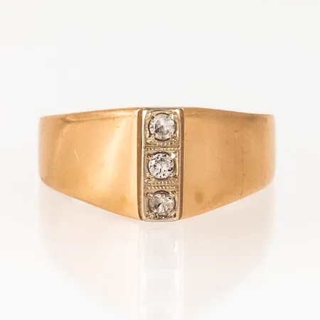Ring i 18K guld med vita syntetiska stenar. Den är i storlek 17½, är 3 - 9 mm bred och väger 4,5g. Stämplad 18K, svensk importstämpel. Bruksslitage.