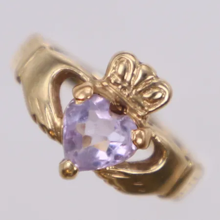 Ring med rosa sten, Claddagh-ring är en traditionell irländsk förlovnings- eller vigselring. Namnet kommer från en irländsk stad, Claddagh, som ligger strax utanför Galway, Irland. Man har lyckats spåra ringens historia till 1600-talet. Ringen är i form av en hand som håller i ett hjärta krönt med en krona, stl 14¾, bredd 10,5mm, 10K Vikt: 1,9 g