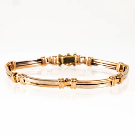 Armband i 18K röd- och vitguld. Det är 18,5 cm långt, är 4,5 - 6 mm brett och väger 19,7g. Kistlås. Italienska stämplar. Bruksslitage, slitna länkar. 