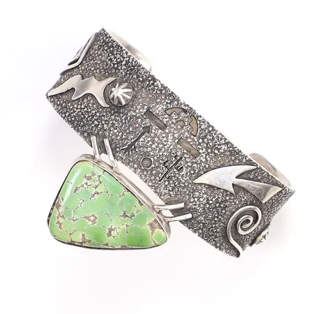 Armring med grön sten troligen grön turkos, tillv. T Benally, Navajo, USA, innermått ca 66x43mm, ena klon son fäster stenfattning till armband har lossnat, silver 925/1000 Vikt: 78,4 g