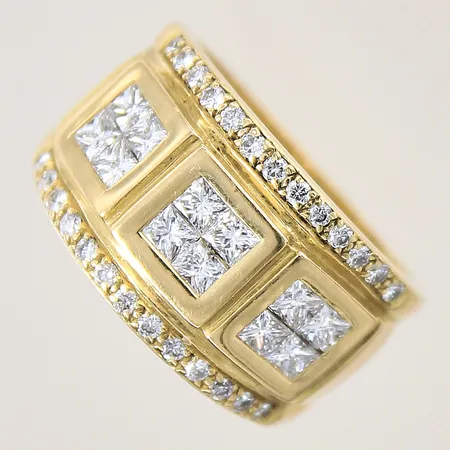 Ring med prinsesslipade diamanter 12 x ca 0,10ct, en sten med nagg, samt briljantslipade diamanter 26 x ca 0,015ct, Kvalitet ca TW-W(G-H)/VS-SI, stl 18¼, bredd 8,2-13,2mm, mindre buckla på skenan på baksidan, mindre hack på skenan vid fattning, 18K Vikt: 13 g