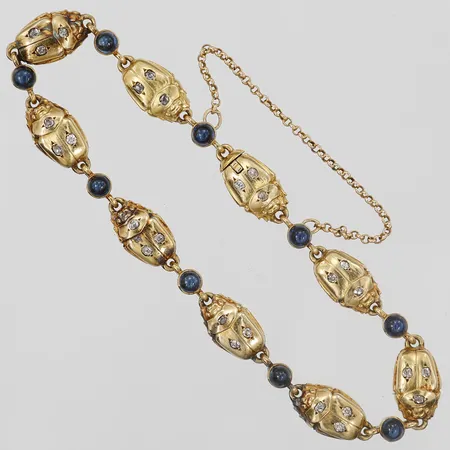 Armband med antikslipade diamanter 27 x ca 0,01ct samt cabochonslipade safier, dekor av skalbaggar, längd: 18 cm, bredd: 1 - 7 mm, utländska stämplar, 18K guld. Vikt: 18,8 g