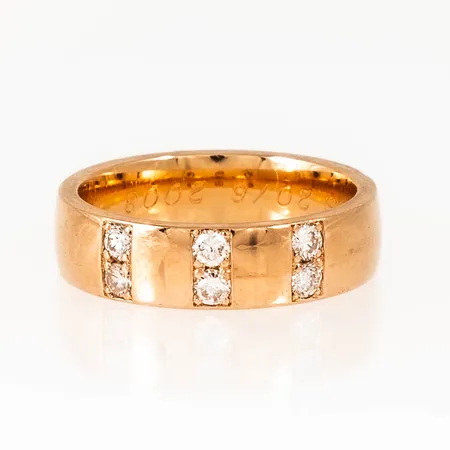 Ring i 18K guld med 6 x ca 0,04ct briljantslipade diamanter. Den är i storlek 17, är 5,2 mm bred och väger 7,3g. Stämplad SCHALIN, 18K & kattfot. Gravyr. 