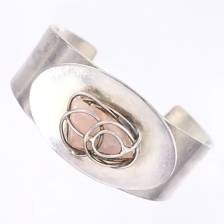 Armring med rosa sten, ca 60x50mm internt, bredd 16-29mm, stämplad "DS Handmade in Denmark", vitmetall