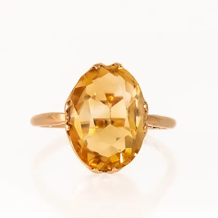 Ring i 18K guld med en orange sten (sitter lite löst i fattningen). Den är 1,5 - 16,4 mm bred, är i storlek 18 (oval skena) och väger 4,1g. Gravyr.