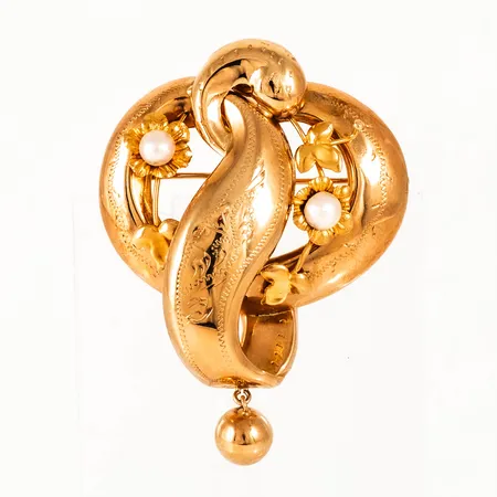 Berlock / brosch i 18K guld med två pärlor. Den är 52,2 x 38,8 mm exkl. infällbar ögla och väger 6,8g. Tillverkad 1949 av Juvelfabriken i Stockholm. 
