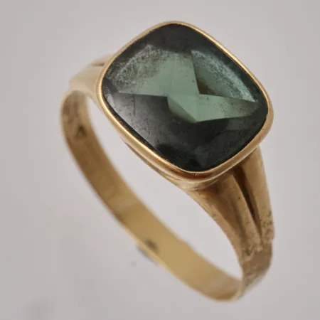 Klackring i 18K guld, stl 21½, bredd 2,9-11,4mm, 1st grön sten, mått 11x13mm, skev i skenan bruttovikt 4,12g, ca nettovikt 2,58g.