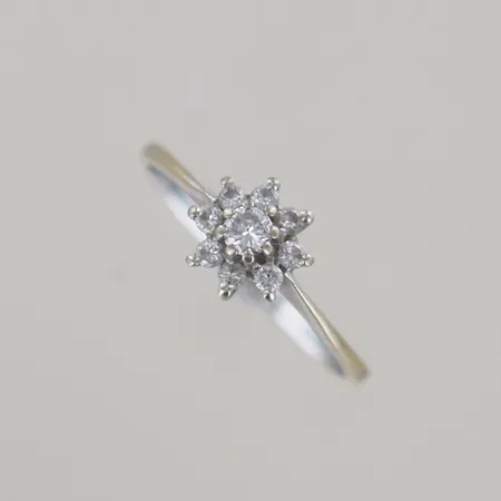 Ring med diamanter 1x 0,05ct + 8 x 0,01ct VS, Ø 16 mm, blommans bredd 6 mm, vitguld 18k Vikt: 1,5 g