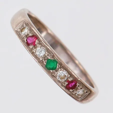Ring med smaragd 1 x ca 0,04ct, rubiner 2 x ca 0,04ct, samt briljantslipade diamanter 4 x ca 0,04ct, stl: 18½, bredd 3mm, vitguld 18K.  Vikt: 4,7 g