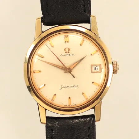 Armbandsur Omega Seamaster, guld på stål, manuell, 33,5mm, datum, repigt plexiglas och boett, skadad urtavla och visare, läderarmband ej original, behov av service, inga tillbehör. 