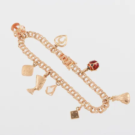 Armband Bismarck med 8 st berlocker, längd ca 19 cm, bredd 5.4 mm, 18k. Vikt: 17,6 g