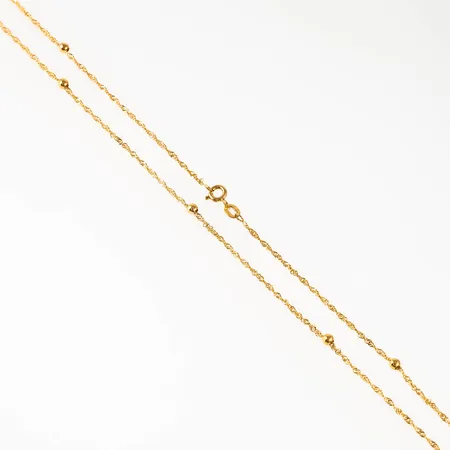 Oanvänd singaporekedja i 9K guld med 3 mm´s kulor. Den är 45 cm lång, 1,5 mm bred och väger 1,9g. Springring. Nypris idag 2898kr.