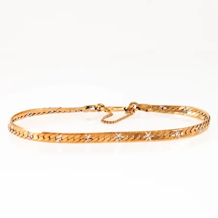 Halvstelt armband i 18K guld med facettslipad dekor i vitt guld. Det är 19 cm långt, 3,9 mm brett och väger 8,5g. Karbinhake och säkerhetskedja. Från Unoaerre. Stämplat 750.