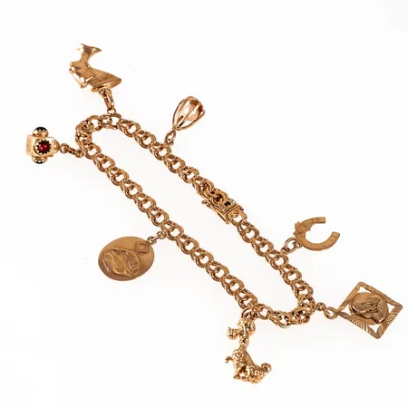 Armband bismarck i 18K guld med sju berlocker. Det är 5,2 mm brett, 19,5 cm långt och väger 18,2g. Kistlås. 