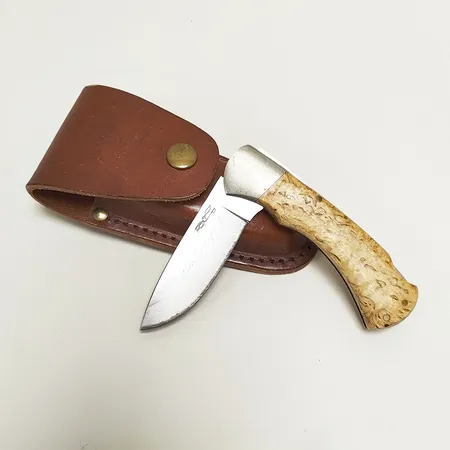 Fällkniv, J. Marttiini Finland, längd ca 19,5cm, handtag i Masurbjörk, fodral i läder, gravyr på blad. 