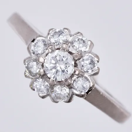 Ring med 9 diamanter totalt ca 0,57ct enl gravyr, 1xca 0,22ct W(H)/VS, 8xca 0,043ct, stl: ca 18, bredd: ca 1,5-10mm, K&EC, Ceson Guldvaru Ab, Göteborg, år 1980, vitguld, 18K  Vikt: 4,1 g