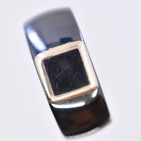 Ring svart legering, stl 19¾, bredd 10 mm, 14K. Bruttovikt 11,1g.